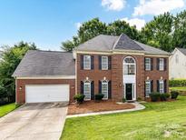 Charming two-story brick home boasts a well-manicured lawn, classic shutters, and an attached two-car garage at 3533 Weddington Ridge Ln, Matthews, NC 28105