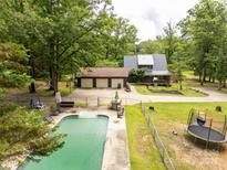 Sprawling property featuring a beautiful pool, detached garage, and a charming home surrounded by mature trees at 3547 Willowood Pond Dr, Rock Hill, SC 29730
