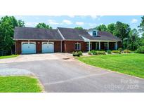 Charming brick home with attached two-car garage, well-maintained lawn, and inviting front porch at 4010 Carlton Dr, Claremont, NC 28610