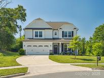 Charming two-story home with a two-car garage, manicured lawn, and beautiful landscaping at 4535 Falls Lake Sw Dr, Concord, NC 28025