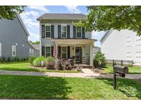 Charming two-story home with a cozy front porch and well-manicured lawn at 6029 Phyliss Ln, Mint Hill, NC 28227