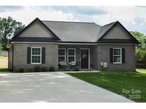 Charming brick home with black accents, cozy front porch and a long driveway at 604 E Ohio Ave, Bessemer City, NC 28016