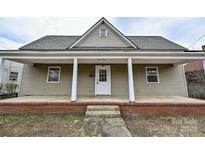 Charming home featuring a quaint front porch, neutral siding, and well-maintained landscaping at 613 E Liberty St, Salisbury, NC 28144