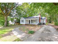 Charming single-story home features a walkway, lush trees, and a spacious front yard at 636 Forest Nw St, Concord, NC 28025