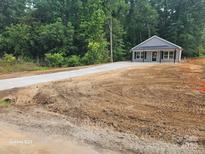 Charming single-story home with a long driveway and lush landscaping, perfect for serene living at 814 Generation Ln, Clover, SC 29710