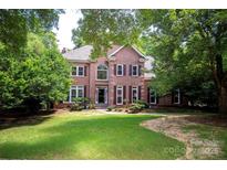 Traditional two-story brick home with well-maintained lawn and mature trees at 10408 Hadleigh Pl, Charlotte, NC 28210