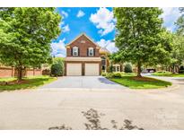 Beautiful brick home with well-manicured lawn, mature trees, and a two-car garage at 10418 Pullengreen Dr, Charlotte, NC 28277