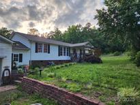 Charming single-Gathering home with a well-kept yard, trees, and a welcoming front porch at 1116 Lewis Ferry Rd, Statesville, NC 28677