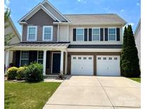 Charming two-story home with a well-manicured lawn and a two-car garage at 11511 Wilson Mill Ln, Pineville, NC 28134