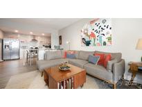Open concept living room and kitchen area with modern decor and natural light at 1300 Reece Rd # 206, Charlotte, NC 28209