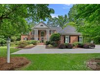 Elegant brick home with stately white columns, manicured landscaping, and a welcoming entrance at 1317 Longleaf Ct, Matthews, NC 28104