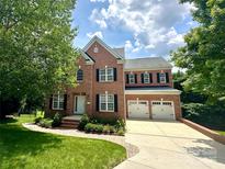 Charming two-story brick home with a two-car garage, manicured lawn, and beautiful landscaping at 14746 Greenpoint Ln, Huntersville, NC 28078