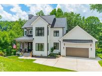 Beautiful two-story modern farmhouse with white siding, stone accents, and a two-car garage at 1543 Withers Dr, Denver, NC 28037