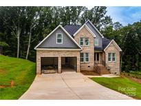 Beautiful two-story brick home with a spacious two-car garage and modern architectural details at 236 Mark Ryan Ln, Dallas, NC 28034