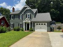 Charming two-story home with a well-manicured lawn, attached garage, and craftsman details at 4221 Hounds Run Dr, Matthews, NC 28105