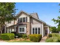 Charming townhome featuring stone accents, lush landscaping, and a welcoming front entrance at 448 River Park Rd, Belmont, NC 28012
