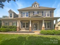 Charming two-story home featuring a welcoming front porch and beautifully landscaped front yard at 5003 Tremont Dr, Indian Trail, NC 28079