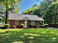 Quaint brick home with well-kept lawn, showcasing classic charm and comfort at 5722 Oak Dr, Charlotte, NC 28216