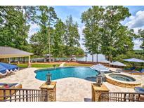 Stunning backyard oasis featuring a pool, hot tub, and lake access at 6216 North Rd, York, SC 29745