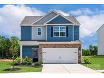 Two-story home with blue siding, brick facade, and a two-car garage exudes modern curb appeal at 7008 Jerimoth Dr, Charlotte, NC 28215