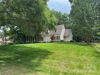 Charming home featuring a well-manicured lawn and mature trees, offering a serene and inviting curb appeal at 7137 Sythe Ct, Charlotte, NC 28226