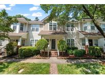 Inviting townhome featuring well-manicured landscaping, front porch, and charming curb appeal at 8310 Brickle Ln, Huntersville, NC 28078