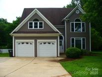 Charming home featuring a two-car garage, well-maintained landscaping, and architectural details at 9228 Old Barnette Pl, Huntersville, NC 28078