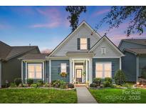 Charming blue two-story home with a landscaped front yard, inviting entry, and lovely flower boxes beneath the windows at 1009 Hercules Dr, Indian Trail, NC 28079