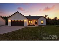 Charming home showcasing a well-manicured lawn and a modern farmhouse design at dusk at 1019 Null Rd, Lincolnton, NC 28092