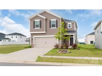 Two-story home featuring a two-car garage, tan siding, a manicured lawn and well-maintained landscaping at 1022 Jeffery Dean Ct, Albemarle, NC 28001