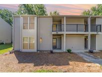 A charming exterior shot of a condo featuring a private balcony and a combination of siding and architectural details at 11049 Cedar View Rd, Charlotte, NC 28226