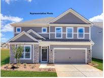 Charming two-story home featuring stone accents, a two-car garage, and a well-manicured lawn at 139 Asmodean Ln, Troutman, NC 28166