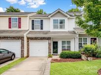 Charming townhome featuring stone accents, a single-car garage, and well-maintained landscaping at 13909 Singleleaf Ln, Charlotte, NC 28278