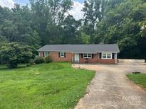 Charming one-story brick home with a well-maintained front lawn and a spacious driveway at 2116 Dana Pl, Shelby, NC 28152