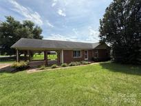 Charming single story brick house with well-manicured lawn and attached covered carport at 2547 Nc 182 Hwy, Lincolnton, NC 28092