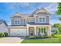 Charming gray two-story home featuring a manicured lawn, attached garage, and welcoming front porch at 3041 Winged Teal Ct, Belmont, NC 28012