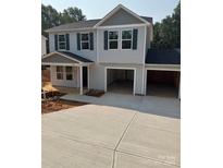 Two-story home featuring a driveway and a two-car garage with an attractive, light gray exterior and dark shutters at 323 Conner St, Lancaster, SC 29720