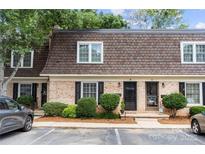 Charming townhouse exterior showcasing brick facade, manicured bushes, and a well-maintained brown shingle roof at 3500 Colony Rd # B, Charlotte, NC 28211