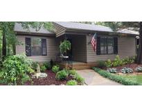 Inviting exterior featuring a charming entrance with well-manicured landscaping, an American flag, and a hanging fern at 353 Tall Oaks Trl, Fort Mill, SC 29715