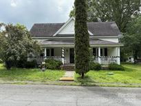 Charming two-story home with a covered front porch and mature landscaping at 65 Maynard Ave, Ansonville, NC 28170