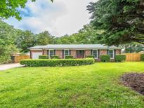 Charming brick home with a well-manicured front yard, lush landscaping, and a welcoming double-door entrance at 7416 Quail Ridge Dr, Charlotte, NC 28226