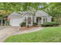 Charming single-story home with a well-manicured lawn, arched windows, and an attached garage at 9011 Brad Ct, Matthews, NC 28104