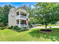 Charming two-story home with a double stacked front porch, green lawn, and mature shade tree at 112 E Heart Pine Ln, Statesville, NC 28677