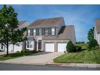 Charming two-story home featuring a brick facade, two-car garage, and well-manicured lawn at 1498 Burrell Nw Ave, Concord, NC 28027