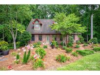 Charming brick home featuring dormers and a beautifully landscaped front yard with colorful flowers at 169 Primrose Ln, Statesville, NC 28625