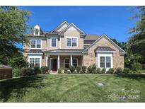 Inviting two-story home featuring a manicured lawn, brick accents, and a covered front porch with columns at 398 Hampton Trail Dr # 97, Fort Mill, SC 29708