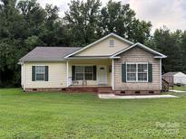 Charming single-story home with a well-maintained lawn, inviting front porch, and lovely curb appeal at 40287 Palmerville Rd, New London, NC 28127