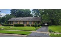 Charming brick home with mature landscaping and a convenient covered parking area at 7017 Knightswood Dr, Charlotte, NC 28226