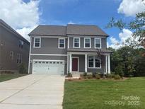 Charming two-story home featuring a pristine lawn, attached two-car garage, and a welcoming front porch at 893 Regulus Ct # 40, York, SC 29745