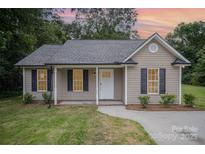 Charming one-story home featuring black shutters, a welcoming front porch and manicured landscaping at 903 Brookdale St, Kannapolis, NC 28083